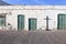 Traditional house in Lanzarote with chalked walls and green windows and doors