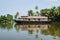 Traditional houseboat in the Kerala backwaters along palm tree coastline, Alappuzha, Alleppey, India