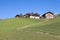 Traditional houses in a cloudy mornig surrounded by green pasture next to the little town of St. Magdalena in Val di Funes