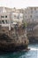 Traditional houses on dramatic cliffs with caves rising from Adriatic sea in Polignano a Mare, Italy