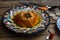 Traditional hummus of red lentil with olive oil and spices, in a traditional colourful plate, rusks and cured meat