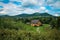 Traditional Hutsul house in the Carpathians in the forest on a sunny summer day. Village two-storey house in Ukraine, Galicia