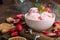 Traditional ice cream served in a glass bowl. Displayed with candy canes on wooden rustic table. Sparkling Christmas tree lights b