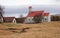 Traditional Icelandic house with red Roof stands on the hills of a yellow dry grass on the background of sky