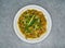 Traditional Indian chicken handi masala as close-up in a plate top view on grey background