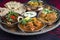 Traditional Indian curry dishes served with rice and pita bread on a traditional thali