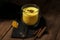 Traditional Indian drink. Golden latte, turmeric milk with spice on a dark wooden background