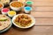 Traditional Indian food and color powders on wooden table. Holi festival celebration