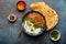 Traditional Indian Punjabi dish Dal makhani with lentils and beans in black bowl served with basmati rice, naan flat