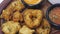 traditional indian snack food, crispy deep fried vada and chutneys close up in a serving plate