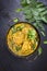 Traditional Indian yellow chicken curry in a korai