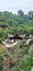 Traditional Indonesian buildings with identical roofs in the natural attractions of The Great Asia Africa surrounded by trees.