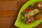 Traditional indonesian catfish soup on a green plate over wooden background