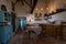 Traditional interior of old village kitchen in historic country house with stucco walls, oak wood beams, vintage wooden furniture