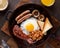 Traditional irish brunch with ham, grilled sausages, toast, mushrooms, beans and fried eggs