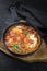 Traditional Israeli national dish shakshouka offered as breakfast with poached eggs in tomato sauce with chili and onions