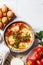 Traditional Israeli shakshuka in gray frying pan. Fried eggs in tomato sauce