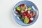 Traditional Italian appetizer bresaola beef jerky on lettuce leaves in a dark plate on a light background, top view