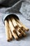 Traditional italian breadsticks grissini with flax seeds on a gray background