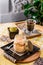 Traditional Italian dessert tiramisu in a jar on a wooden table in the restaurant