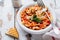 Traditional Italian dish, chowder, pottage, pasta e ceci served in old plate on old wooden background.