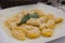 A traditional Italian dish: Pumpkin Gnocchi with Parmesan cheese and a decorative sage leaf