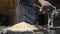 Traditional Italian homemade pasta. Flour falling from hand in slow motion. Close-up shot of adding flour for homemade