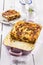 Traditional Italian lasagne baked with pasta sheets and mincemeat on classic design plate and casserole