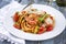 Traditional Italian linguine alla gamberetti with vegetable and parmesan cheese on a classic style plate
