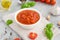 Traditional Italian marinara sauce in a bowl on a concrete background with spices and ingredients. Copy space