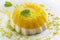 Traditional Italian orange mango pudding with pistachios crumbles and and icing sugar on a classic design plate