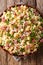 Traditional Italian pasta Ditalini with green peas, ham and cheese closeup on a plate. Vertical top view