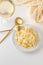 Traditional Italian pasta - Fetuccini Alfredo on a white table with golden appliances