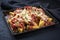 Traditional Italian polenta alla sarda con salsiccia with meat sausage on a rustic black tray