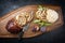 Traditional Italian Porchetta arrotolata pork meat sliced and as piece with pita bread and figs on a modern design wooden board