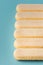 Traditional Italian savoiardi ladyfinger cookies stacked together on a blue pastel background. A pile of sweet sponge biscuits for