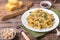 Traditional Italian Sicilian fusilli pasta with bread crumbs and green beans, sprinkled with cheese in a white plate on a wooden