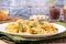 Traditional Italian Sicilian fusilli pasta with bread crumbs and green beans, sprinkled with cheese in a white plate on a wooden