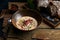 Traditional Italian soup with barley and bresaola on old wooden background. Selective focus. Dark tone.