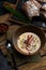 Traditional Italian soup with barley and bresaola on old wooden background. Selective focus. Dark tone.