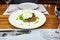 Traditional Italian specialty Burrata Cheese on ceramic plate served with olive oil and green salad over a white rustic