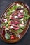 Traditional Italian tagliata beef steak with parmesan and salad on a rustic plate