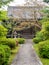 Traditional japan wooden temple with flowers and green trees in front of it