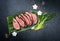 Traditional Japanese barbecue wagyu dry aged fillet steak slices with daikon and leek on a banana leaf