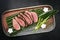 Traditional Japanese barbecue wagyu dry aged fillet steak slices with daikon and leek on a design plate