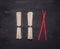 Traditional Japanese buckwheat soba noodles with red chopsticks laid out in a row on wooden rustic background top view close up