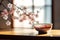 Traditional japanese ceramic cup on a table with blossoming sakura flowers on a background. Generative AI