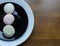 Traditional japanese dessert wagashi mochi rise cake green pink white on black and white plates and wooden background