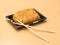 Traditional Japanese food - sushi toast, cut into four pieces with wooden chopsticks on a tray