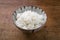 Traditional Japanese koshihikari rice in a design bowl on an old wooden board